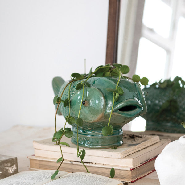 A turquoise debossed stoneware fish planter with a reactive glaze.